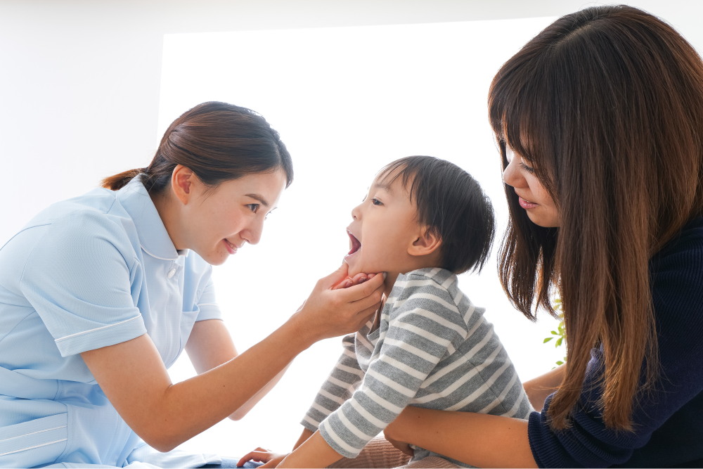 お子様の口の中を確認する歯科衛生士