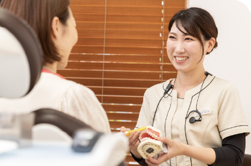受付にて笑顔で診察券を渡す様子